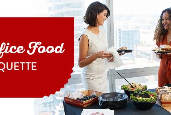 two women enjoying corporate catering and showing office food etiquette