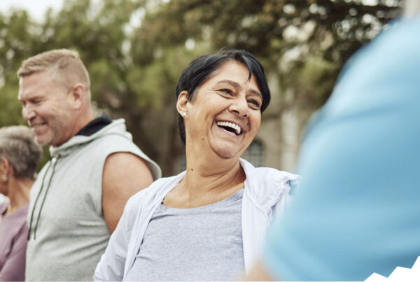 Adults smiling and laughing during a team-building activity at work.